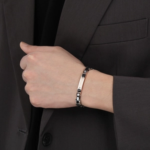 Three-tone stainless steel men's bracelet in silver black and rose gold on a suit wrist