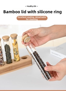 Detailed view of hand opening a glass tube with a bamboo lid and airtight silicone seal