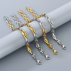 Juego de pulseras de lujo de acero de titanio con eslabones cuadrados en oro y plata.
