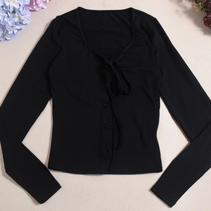 Close-up of black ribbed long-sleeved shirt featuring front buttons and lace-up details