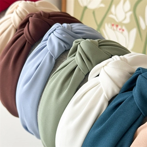 Close-up of knotted fabric headbands in various colors showing ribbed texture detail