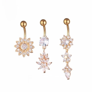 Detailed view of three gold-plated belly rings featuring sunflower and star charms