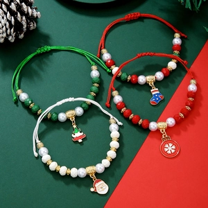 Vue détaillée de bracelets de Noël tressés à la main avec breloques festives et perles colorées