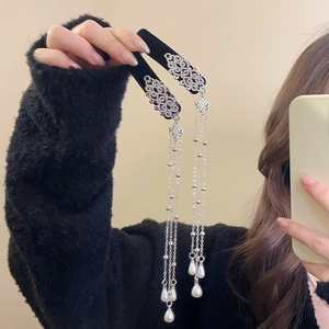 Detailed view of silver Chinese style hair clip with pearls and long flowing tassels