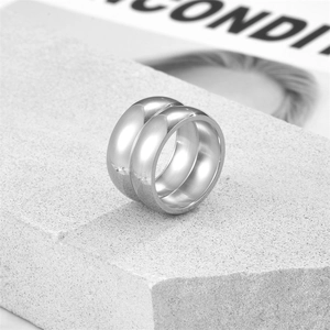 Polished silver stainless steel double-layered ring on a textured grey stone block