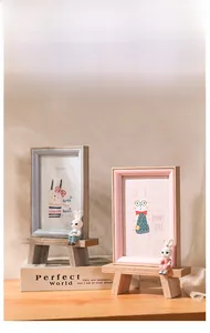 Detail view of Nordic wooden photo frames with bunny figurines on mini benches