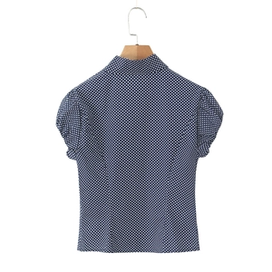 Navy blue polka dot puff sleeve blouse with front buttons and classic collar on a wooden hanger