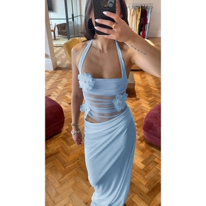 Détail de robe dos nu bleu clair avec fleurs 3D et empiècements en mesh transparent