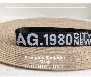 Detail of black nylon strap with AG.1980 CITY NEW lettering on a woven mat background