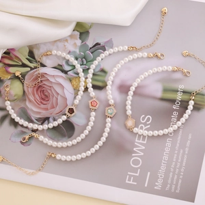 Elegant 18K gold plated pearl bracelet with colorful zircon star charms on a vintage card