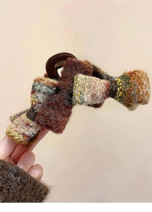 Gros plan sur pince à cheveux en tweed avec nœuds multicolores et texture laine