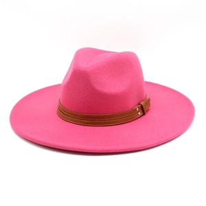 Detail of rose pink fedora hat featuring smooth felt texture and brown leather decorative band