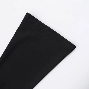 Detail of high-quality black elastic knit fabric and clean stitching on a split maxi dress