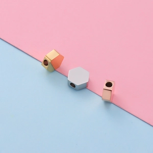 Macro detail of hexagonal stainless steel spacers in gold, silver, and rose gold finishes