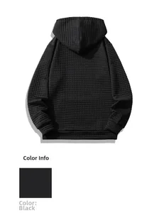 Detail of men's black waffle knit hoodie showing textured fabric and loose fit back
