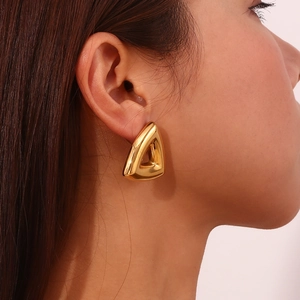 Close-up of a model wearing a polished 18K gold plated triangular geometric earring