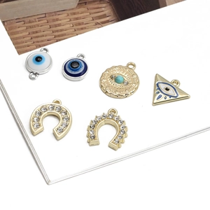 Golden and silver Evil Eye triangle pendants for DIY jewelry making on white background