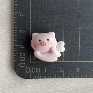 Detail view of mini pink resin pig charm with wings showing size measurement 1.8x1.5cm