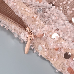 Macro shot of nude pink evening dress showing sequin embroidery and hidden zipper