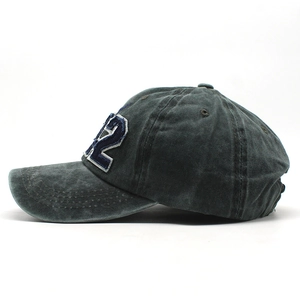 Dettaglio del tessuto in cotone lavato e ricamo 3D del numero 2 sul cappellino da baseball