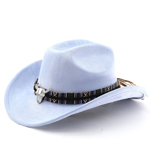 Détail d'un pendentif de crâne de taureau argenté sur un chapeau de cow-boy en daim