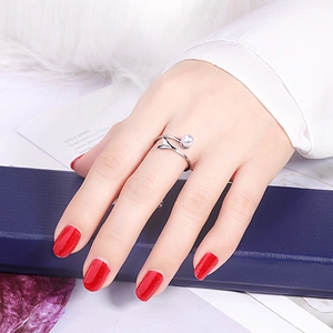 Detailed view of silver fishtail ring with white pearl on model finger