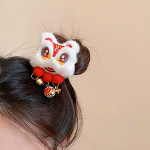 Détail de la pince à cheveux lion danse rouge et blanc avec cloches dorées et gland