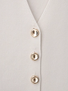 Detailed macro view of beige fine knit fabric texture and golden decorative buttons