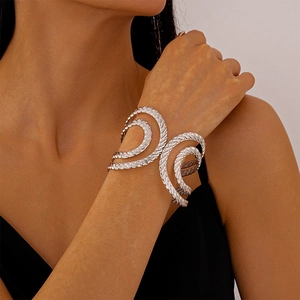 Detail of silver spiral bangle with textured rope design worn by model in black top