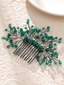 Detail of handmade green crystal hair comb with leaf motif and black metallic wire branches