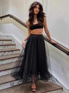 Elegant two-piece black tulle skirt set with tube top on model at marble staircase