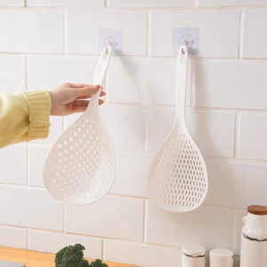 Long handle nylon slotted spoon for kitchen use shown hanging and being held