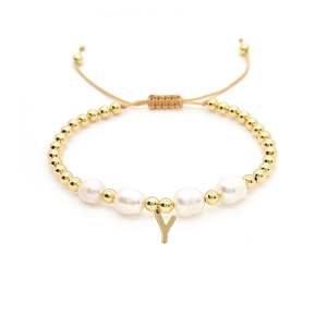 Detailed view of 18K gold beads with natural pearls and a letter Y charm on a gold bracelet