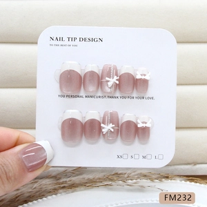 Cat eye press-on nails with white French tips and 3D bow charms in lotus pink