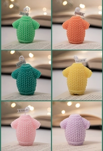 Detailed knit texture of mini sweater-shaped scented candles in six vibrant colors