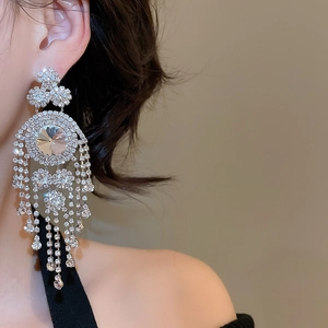 Close-up of elegant rhinestone fringe earrings on a model in French geometric court style
