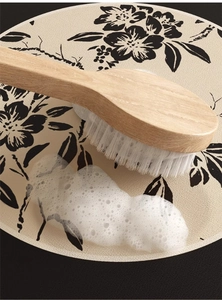 Macro shot of natural wood long handle body brush bristles with rich white cleaning foam