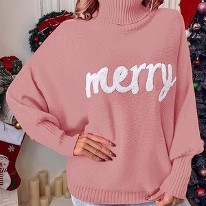 Close-up of pink Christmas turtleneck sweater with merry chenille embroidery and knit texture
