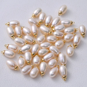 Macro shot of multiple 6mm freshwater pearls with golden metal clasps for DIY jewelry
