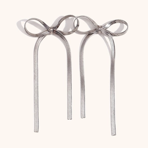 Dettaglio degli orecchini a fiocco argento con eleganti nappe a catena serpente