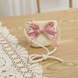 Détail du sac bandoulière en paille pour enfant avec grand nœud rose et tissu floral