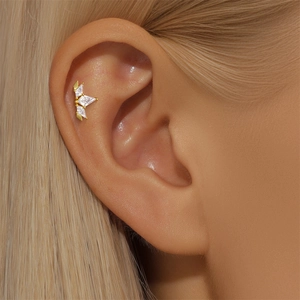 Macro shot of S925 silver gold-plated stud earring with opal and marquise zircon on ear