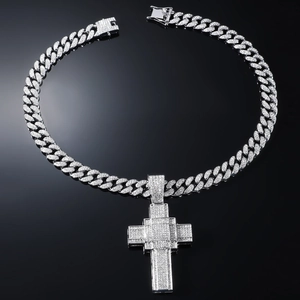 Close-up of silver Cuban chain with ice-out diamond encrusted cross pendant