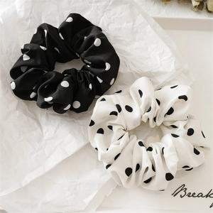 Detail of black and white polka dot chiffon scrunchies with soft fabric texture