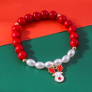 Close-up of Christmas beaded bracelet with red beads and a cute reindeer charm
