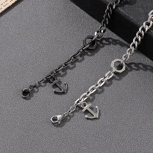 Detail of gunmetal and silver anchor bracelets with chain links and lobster clasp