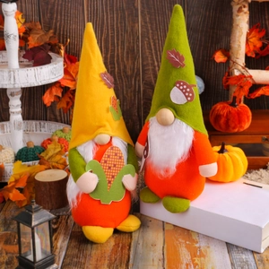 Fall themed plush gnome dolls with yellow hats and maple leaf decor in a warm home setting
