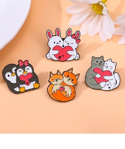 Close-up of cute enamel pins featuring animals like a rabbit and cat holding red hearts