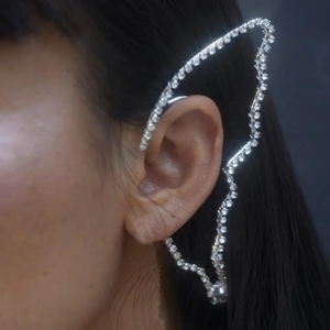 Macro shot of silver butterfly wing ear cuff with rhinestones on a female model
