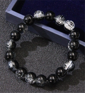 Detail of men's bracelet with black obsidian and white ice crack beads in a jewelry box